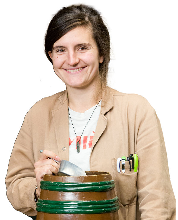 Lachende Sophie van Os bedrijfsleider in de winkel met stofjas en schep